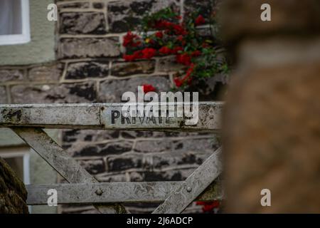 Cartello privato su un cancello bianco, con intemperie a Castleton, Peak District National Park, Derbyshire, Regno Unito. Foto Stock