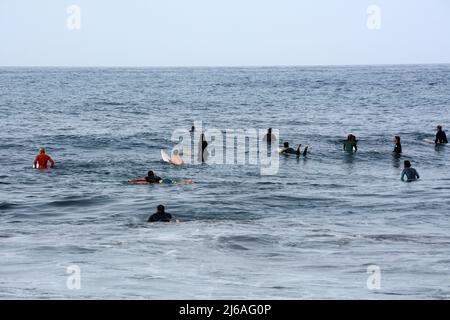 Un gruppo di surfisti in attesa di onde in acque calme alla spiaggia di Playa del Socorro a Los Realejos, sulla costa settentrionale di Tenerife, Isole Canarie, Spagna. Foto Stock