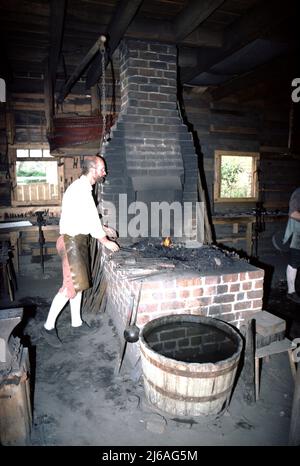 Williamsburg, Virginia. USA 9/1987. Maestri fabbri per il Colonial Williamsburg. Questi smiths artigianale a mano i fissaggi di metallo usati da altri artigiani Colonial Williamsburg quali il wheelright, i fissaggi domestici quali le unghie, le cerniere e le chiusure; e, il secchio di cooper e le cinghie di barile più l'attrezzatura e la riparazione dell'azienda agricola. Foto Stock