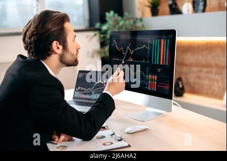 Investitore di successo del commerciante maschio caucasico, analizzando il mercato finanziario di criptovaluta, sguardo focalizzato ad uno schermo, progettando una strategia di criptovaluta, analizzando i rischi. Investimenti, negoziazione in borsa Foto Stock