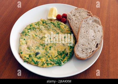 frittata di uova di verdure miste con pomodori, fette di pane Foto Stock