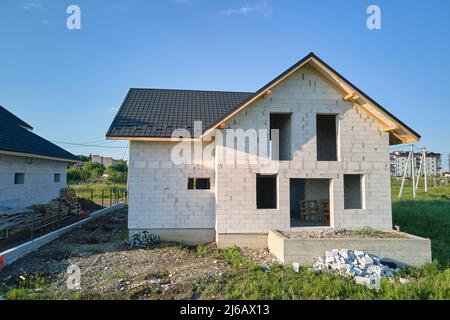 Vista aerea di casa incompiuta con pareti in calcestruzzo leggero aerato e telaio del tetto in legno rivestito con piastrelle metalliche in costruzione Foto Stock