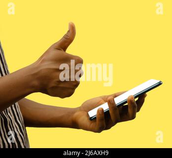 mano giusta che tiene il telefono e che fa i pollici su sfondo giallo, grande app, sì, buon telefono, destra, riuscito, completo, mockup, maschera, ritaglio Foto Stock