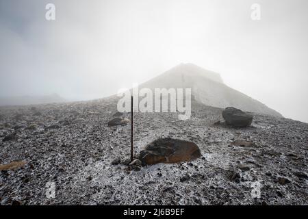 Ripido sentiero per la cima del cratere rosso nella pesante nebbia sul Tongariro Alpine Crossing. Nuova Zelanda. Foto Stock