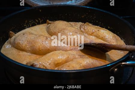 Curry di pollo tailandese rosso che simmering in una padella su un fornello Foto Stock