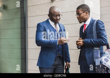 Ritratto di due nero afro-americano uomo d'affari in abiti scambiando biglietti da visita e contatti all'aperto. Foto Stock