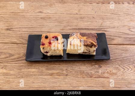 Torta di marmo e un altro con bacche su un tavolo di legno Foto Stock