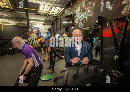 L'uomo d'affari Chris Walsh Reform UK candidato e proprietario locale della palestra con i clienti a Trident Fitness, Morley, West Yorkshire, Inghilterra. Foto Stock