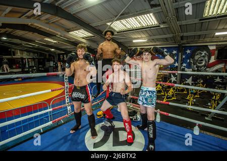 Un gruppo di giovani studenti maschi di boxe thailandesi che si posano al banco di boxe presso la palestra locale nel West Yorkshire, Inghilterra. Foto Stock