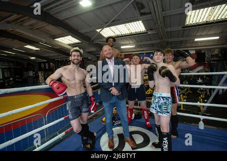 Uomo d'affari Chris Walsh Reform UK candidato e proprietario locale di palestra Trident Fitness in posa con gli studenti alla boxe training , West Yorkshire, Inghilterra . Foto Stock