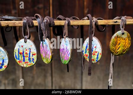 Gruppo di collane colorate dipinte a mano e di souvenir esposti in vendita in un tradizionale mercato del fine settimana a Bucarest, Romania Foto Stock