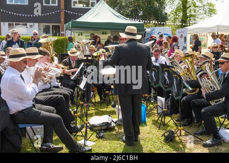 Downton, Salisbury, Wiltshire, Regno Unito, 30th aprile 2022. Downton Cuckoo Fair è tornato in un caldo sole primaverile glorioso dopo una pausa per la pandemia di Covid. L'evento popolare, con bancarelle di mercato e atti di strada, attrae una folla di migliaia di persone. Downton Brass Band gioca per la folla. Credit: Paul Biggins/Alamy Live News Foto Stock