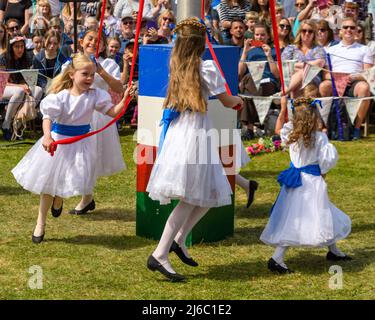 Downton, Salisbury, Wiltshire, Regno Unito, 30th aprile 2022. Downton Cuckoo Fair è tornato in un caldo sole primaverile glorioso dopo una pausa per la pandemia di Covid. L'evento popolare, con bancarelle di mercato e atti di strada, attrae una folla di migliaia di persone. I giovani ballerini maypole in rosso, bianco e blu mettono il loro piede migliore in avanti. Credit: Paul Biggins/Alamy Live News Foto Stock