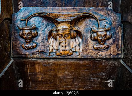 I Misericords sono piccole strutture di legno formate sul lato inferiore di una sede pieghevole in una chiesa. Qui visto nella chiesa parrocchiale di St Laurence a Ludlow. Foto Stock