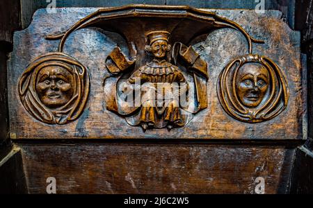 I Misericords sono piccole strutture di legno formate sul lato inferiore di una sede pieghevole in una chiesa. Qui visto nella chiesa parrocchiale di St Laurence a Ludlow. Foto Stock