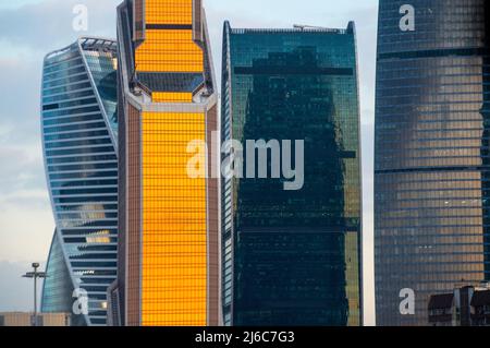 Grattacieli di vetro della città di Mosca al tramonto, vista ravvicinata di vari edifici. Edifici blu e arancione. Russia Foto Stock