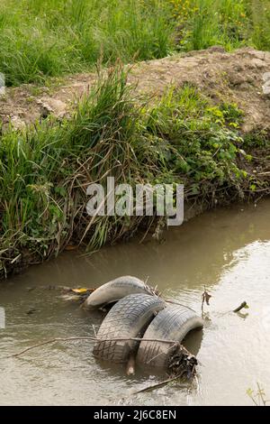 Italia, Lombardia, veicolo pneumatico abbandonato in acqua Foto Stock