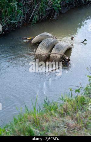 Italia, Lombardia, veicolo pneumatico abbandonato in acqua Foto Stock