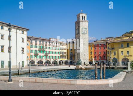 Riva del Garda, Italia - 22 marzo 2022: Piazza della catena con l'antica torre dell'Apponale con il porto del lago in primo piano Foto Stock