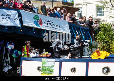 Londra, Regno Unito. 30 aprile 2022. La gente guarda gli studenti d'arte dell'Università di Londra che organizzano una performance di danza a bordo di un battello a barca stretta durante l'Inland Waterways Association (IWA) Canalway Cavalcade a Little Venice per celebrare il meglio della vita sui canali d'acqua di Londra e della sua comunità. L'evento si svolge nei primi mesi del fine settimana delle feste di fine maggio e dopo essere stato annullato a causa della pandemia, il tema di quest'anno è "Bentornato". Credit: Stephen Chung / Alamy Live News Foto Stock