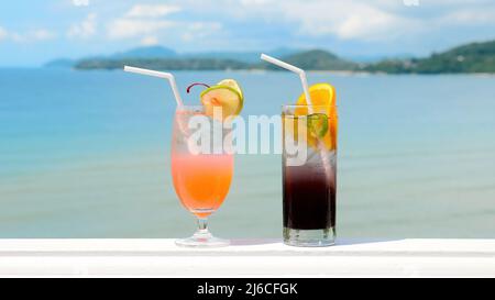 Due bicchieri di cocktail tropicali ghiacciati e non alcolici con oceano Foto Stock
