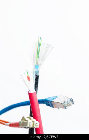 Tagliare il cavo in fibra ottica con connettori in fibra ottica e un cavo patch RJ45 su sfondo bianco Foto Stock