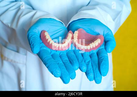 protesi nelle mani di un dentista Foto Stock