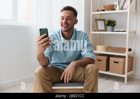 Felice carino gioioso parlare con un amico utilizzando telefono videochiamata discute le ultime notizie piacevole sollevare sorrisi guarda lo schermo. Comunicazione a distanza Foto Stock