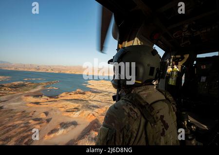 Personale Sgt. Dominic Brinker, 66th Rescue Squadron (RQS) istruttore di aviatore missioni speciali, aiuta i piloti guida in per l'atterraggio alla base dell'aeronautica di Nellis, Nevada, 28 aprile 2022. La missione del RQS 66 è quella di fornire forze di soccorso e di ricerca da combattimento rapidamente dispiegabili, agili e rapide in risposta alle operazioni di emergenza in tutto il mondo. (STATI UNITI Air Force foto di Senior Airman Zachary Rufus) Foto Stock