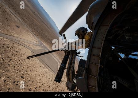 Personale Sgt. Dominic Brinker, 66th Rescue Squadron (RQS) istruttore di aviatore missioni speciali, sgomma una mini pistola durante la formazione di routine sul Nevada Test and Training Range alla base dell'aeronautica di Nellis, Nevada, 28 aprile 2022. I miglioramenti di combattimento di Pave Hawk includono un ricevitore di avvertimento radar, un jammer infrarosso ed un sistema di erogazione di contromisura di lanciapaglia/svasatura. (STATI UNITI Air Force foto di Senior Airman Zachary Rufus) Foto Stock