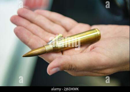 Mano tiene piccolo calibro e pallottole kalashnikov pistola primo piano Foto Stock