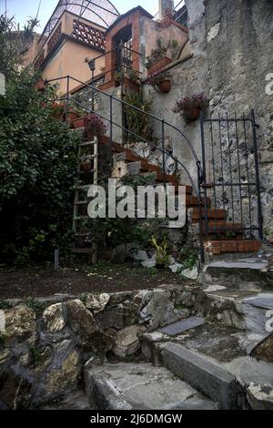 Chiesa e il suo campanile circondato da edifici visti da dietro e sotto una scogliera in una giornata nuvolosa Foto Stock