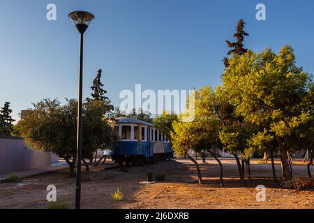 Lavrio, Grecia - 28 luglio 2021: Tram vecchio in un parco a Lavrio. Coperto di graffiti e senza vetro della finestra..scartato tram tra gli alberi in un parco. MU Foto Stock