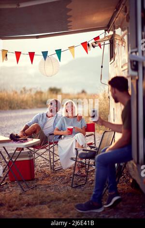 Amici che si divertono all'aperto.allegro amici che festeggiano vicino moderno Camper Van in Campeggio Foto Stock