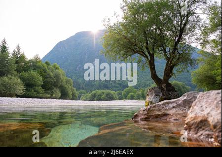 Bellissimo scenario naturale di un sole che sorge da dietro le montagne e bel fiume calmo di SOA che scorre attraverso la valle. Foto Stock