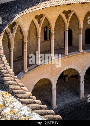 Fotografia di colonnato in stile romanico al piano terra e galleria in stile gotico al primo piano preso dal tetto all'interno del Castell de Bellver Foto Stock