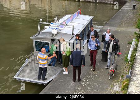 Basilea, Svizzera - Aprile 2022: Gruppo di persone in visita a Basilea che prendono un piccolo taxi d'acqua per attraversare il fiume Rine. Foto Stock