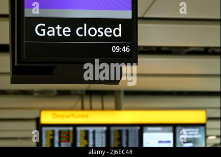 Display elettronico in un terminal aeroportuale che mostra ai passeggeri il cancello per la bordatura dell'aereo è chiuso. Nessuna gente. Foto Stock