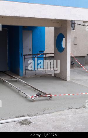 Area cieca intorno alla casa. Costruzione di casseri per la zona cieca della casa. Nastro di costruzione intorno al pavimento di cemento Foto Stock