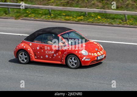 "BE Kind" 2004 arancione personalizzato VW Volkswagen Beetle 8V 1596cc con capote manuale a 5 velocità; guida sull'autostrada M61, Regno Unito Foto Stock