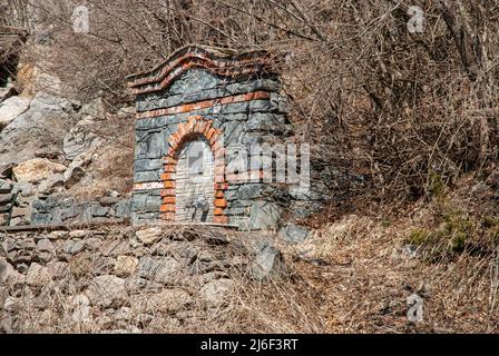 Fontana di montagna in pietra con acqua pura e limpida proveniente dalla sorgente naturale con conduttura continua Foto Stock