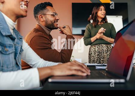 Gruppo di uomini d'affari diversi che hanno una riunione in una sala riunioni. Giovani uomini d'affari sorridendo felicemente durante una discussione. Uomini d'affari multietnici Foto Stock