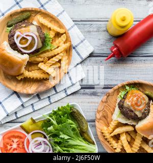 Cheeseburger slider con patatine fritte e un piatto di condimenti Foto Stock