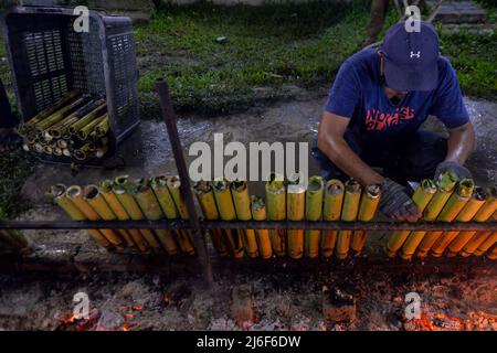 1 maggio 2022: Un uomo prepara ''lemang'', un cibo tradizionale a base di riso glutinoso e cocco, cucinato in un tubo di bambù scavato davanti alla celebrazione di Eid-al-Fitr a Seremban, Negeri Sembilan, Malesia. (Credit Image: © Fuad Nizam/ZUMA Press Wire) Foto Stock