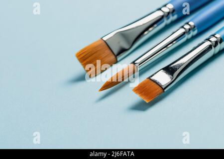 Pulire nuovi pennelli acquerelli su sfondo blu chiaro, arte e creatività concetto, spazio vuoto copia Foto Stock