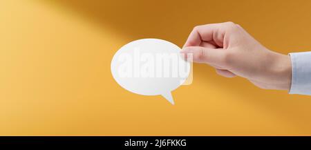 Mano femminile che tiene una bolla bianca del parlato, concetto di comunicazione Foto Stock