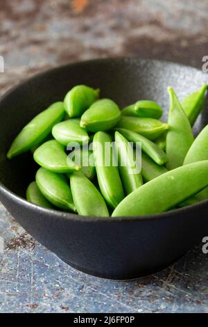 Lo zucchero si inserisce in un recipiente in pietra nera. Su uno sfondo grunge Foto Stock