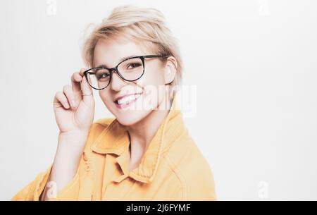 Vista e salute degli occhi. Buona visione. Negozio di ottica. Occhiali alla moda. Donna sorridente bionda indossare occhiali da vicino. Moda per gli occhi. Aggiungi smart Foto Stock