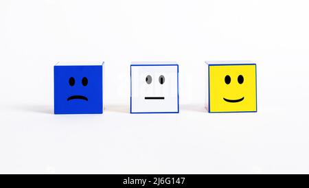 Valutazione e feedback sulla soddisfazione del cliente. Cubi con emozioni tristi e sorridenti. Umore negativo, neutro e positivo per i visitatori o i clienti. Condurre un sondaggio per valutare la qualità del servizio. Foto Foto Stock