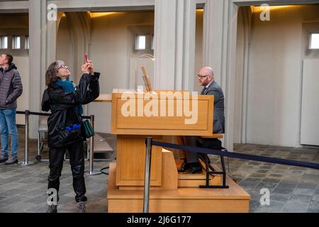 L'organista suona l'organo a pipa per i turisti a Hallgrímskirkja, una chiesa di riferimento, a Reykjavík, Islanda. Foto Stock